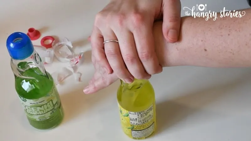 Mit festem Druck die Kugel in die Flasche drücken; Überlaufen kann vorkommen