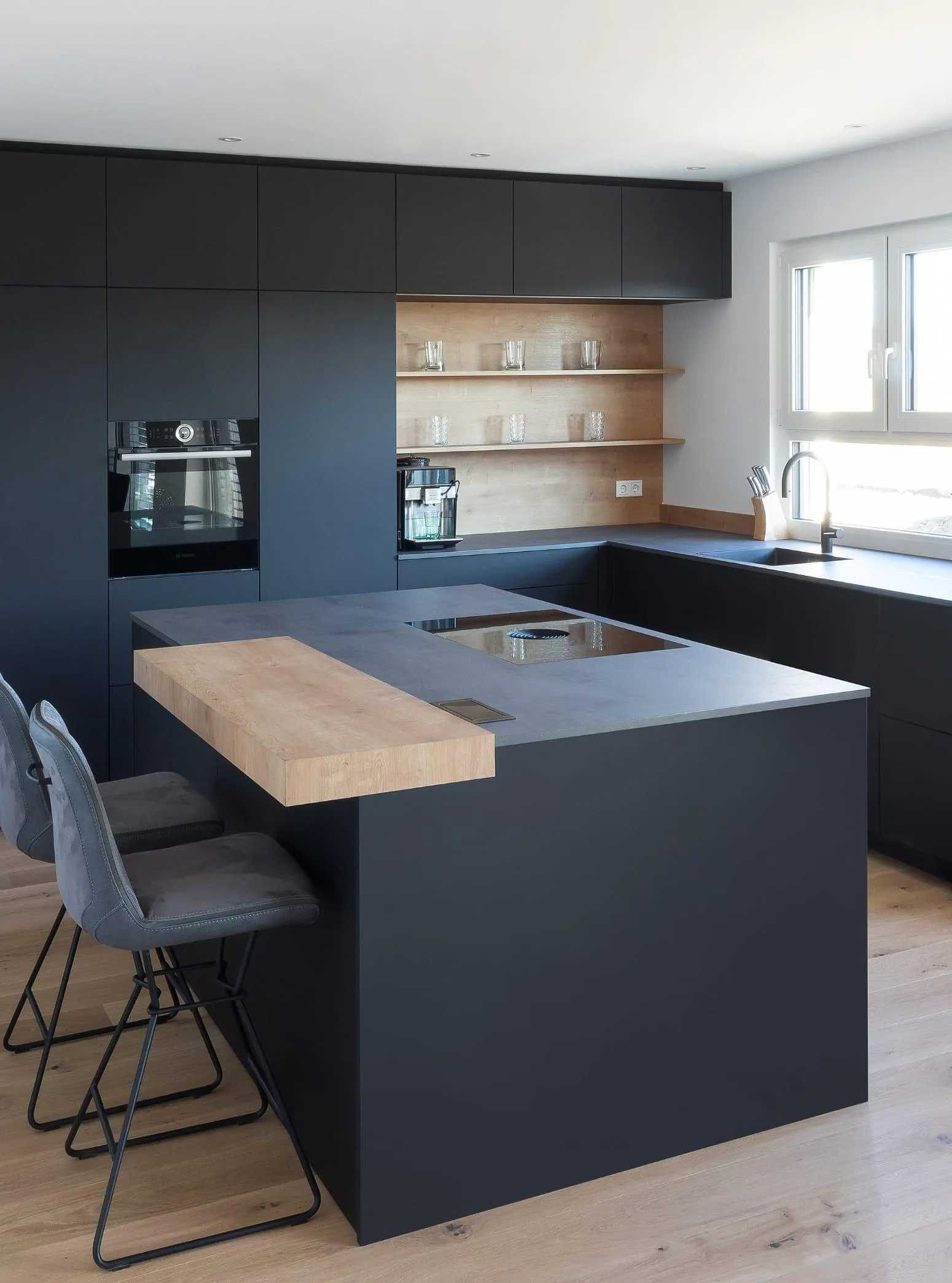 Moderne schwarze Kücheninsel als stilvoller Mittelpunkt mit integrierter Theke und Sitzgelegenheiten