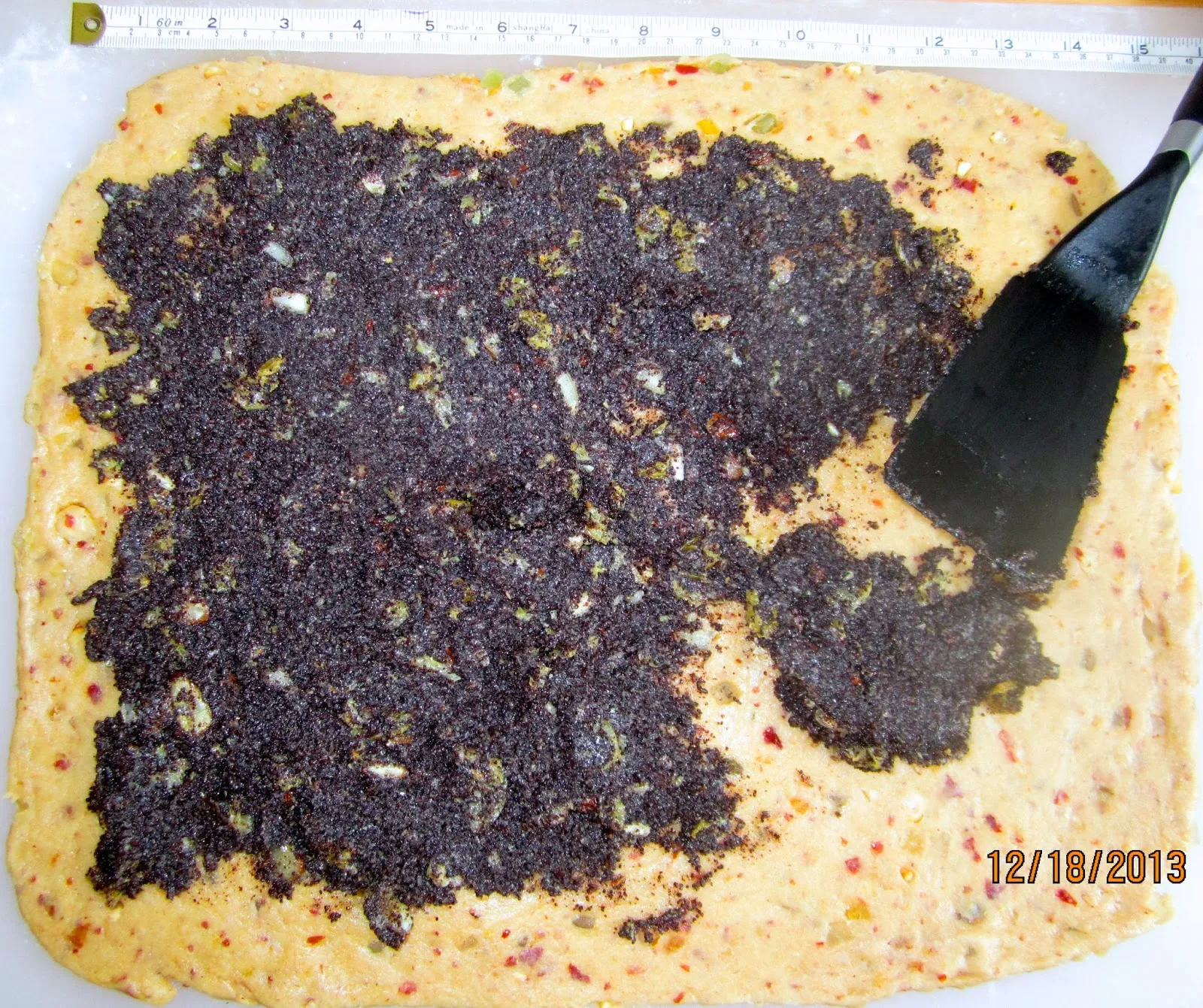 Mohnfüllung gleichmäßig auf dem ausgerollten Teig verteilen