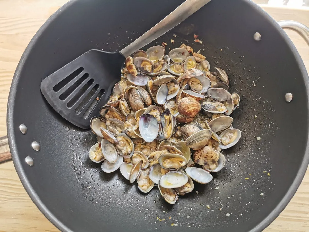 Muscheln in tiefer Bratpfanne mit Knoblauch und Peperoncino.