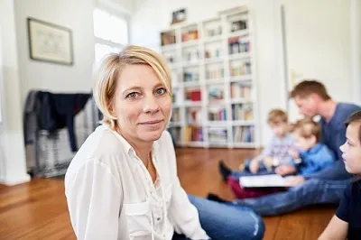 Mutter und Familie im Wohnzimmer, geschützt durch Risikolebensversicherung