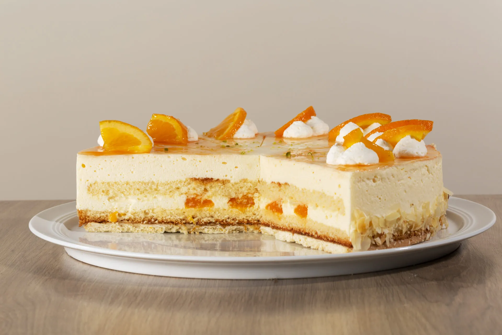 Nahaufnahme der Orangen-Käsesahne Torte mit Mandelsplittern und Orangenscheiben