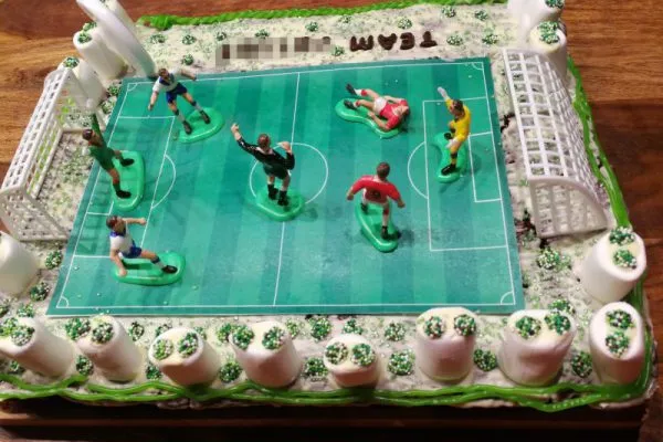 Nahaufnahme des essbaren Fußballfeldes auf dem Geburtstagskuchen