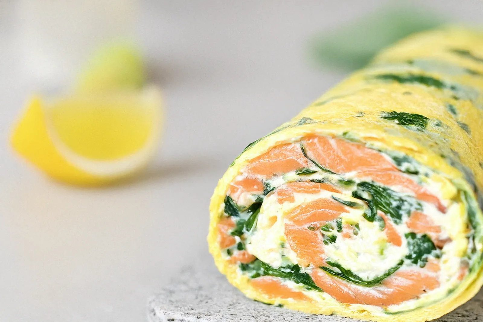 Nahaufnahme einer Lachs-Spinat-Rolle aus Eierteig