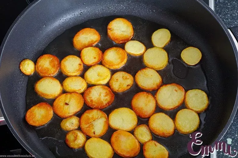 Nahaufnahme einer Pfanne mit einer einzelnen Schicht Kartoffelscheiben, perfekt für das Braten