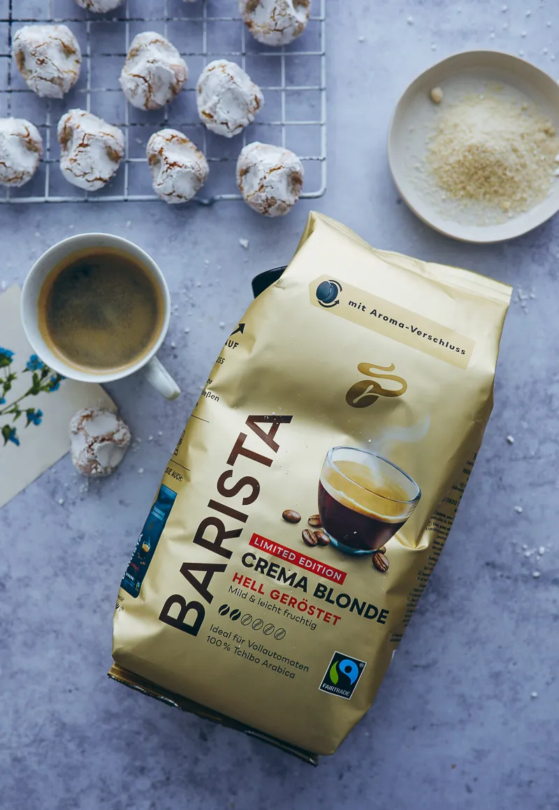 Nahaufnahme einer Tasse Kaffee und zwei Mandelgebäcken