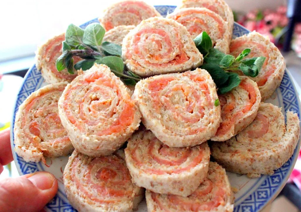 Nahaufnahme von fertig geschnittenen Lachsrollen auf einem Teller