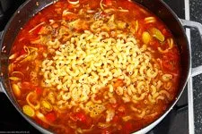 Nudeln und Gemüsebrühe werden in die Pfanne gegeben und geköchelt