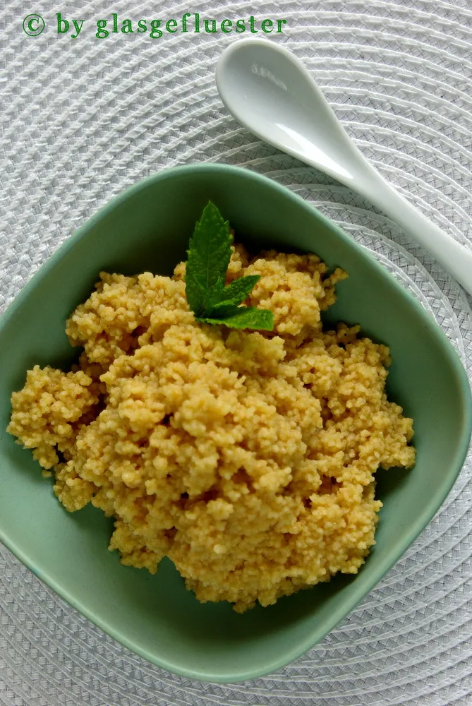 Orangen-Couscous in einer Schale, garniert mit frischen Kräutern