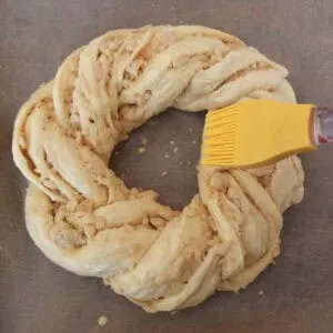 Osterbrot vor dem Backen mit Ei bestrichen