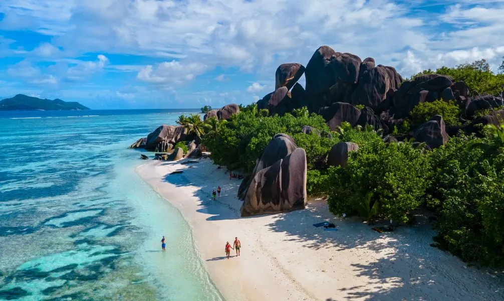Paradiesischer Strand auf den Seychellen mit Felsen und Palmen