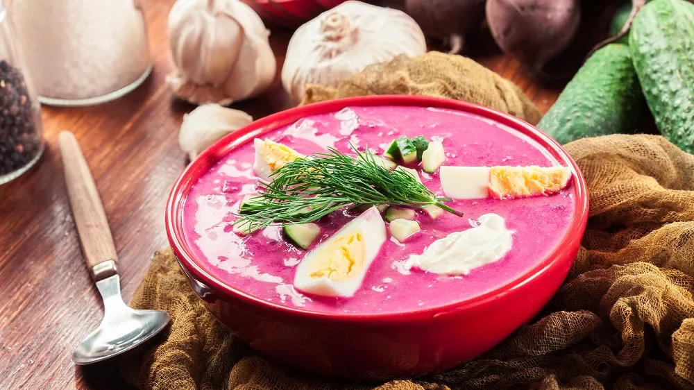Pinker Borschtsch in einer Schale mit Ei und Sahne garniert