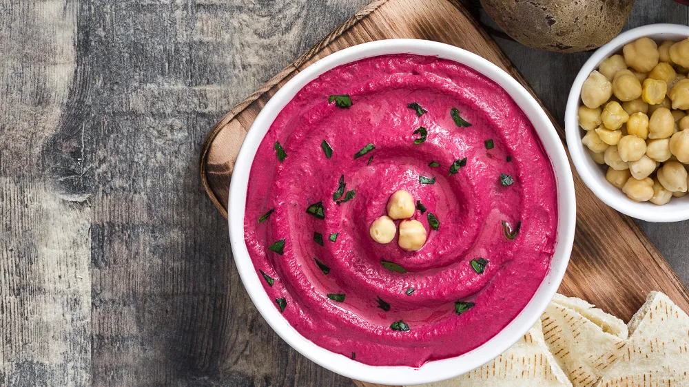 Pinker Rote Bete Hummus in einer Schale mit Brot