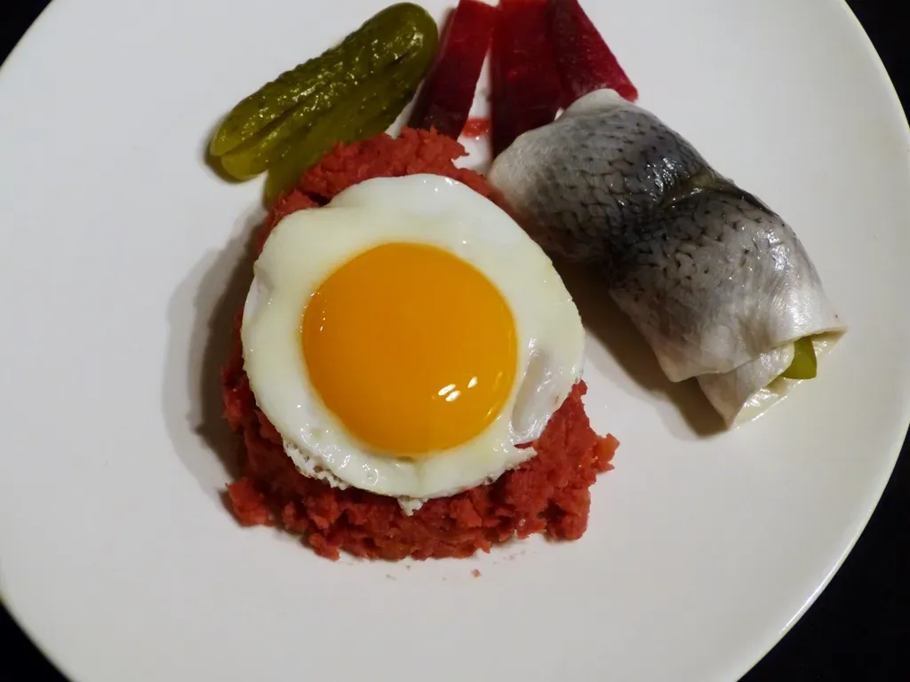 Portion Labskaus mit Roter Bete, Kartoffeln, Corned Beef und einem Rollmops