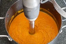 Pürieren: Die fertige Möhren Ingwer Suppe wird mit einem Pürierstab cremig gerührt