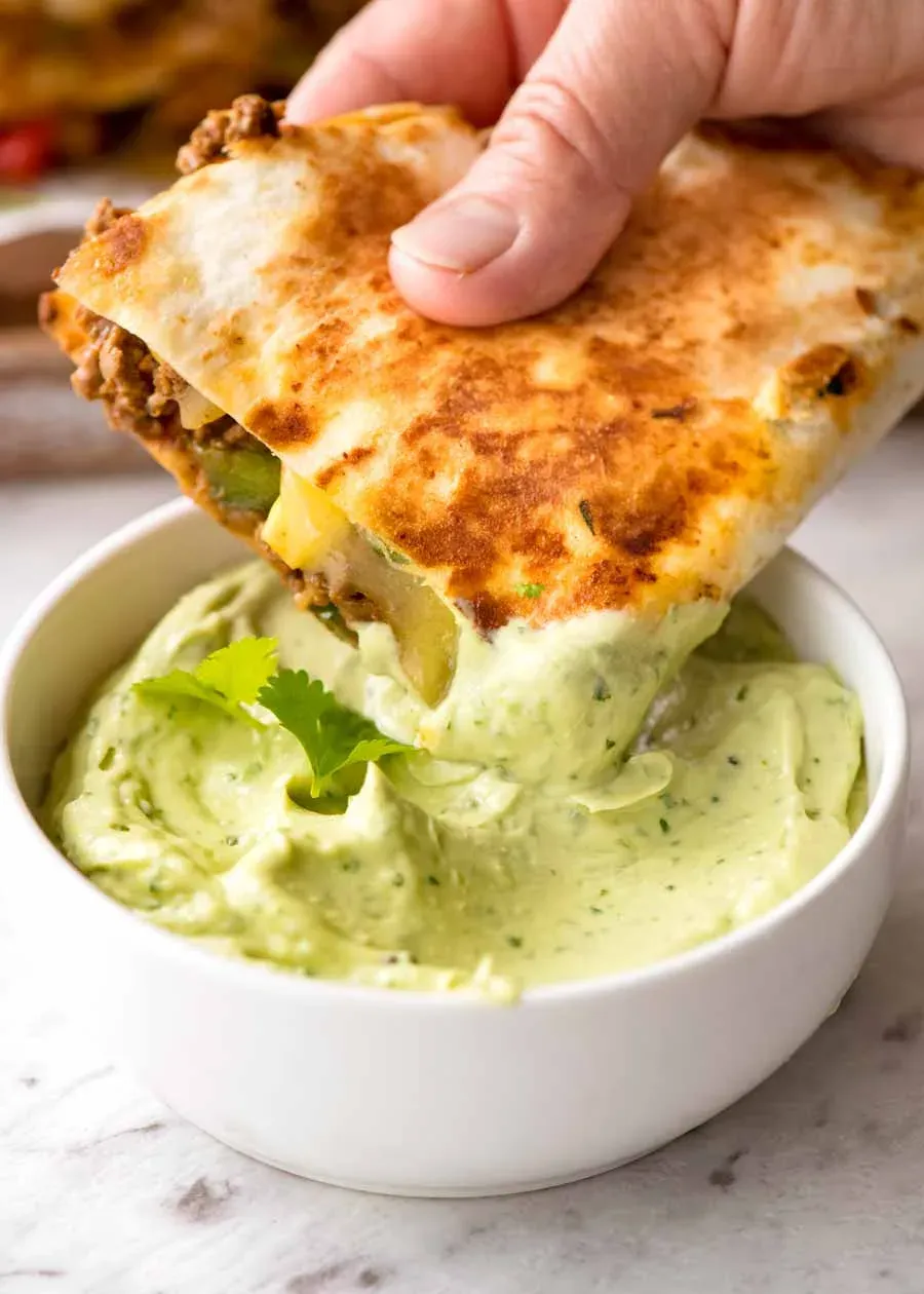 Quesadilla wird in Avocado Sauce getaucht