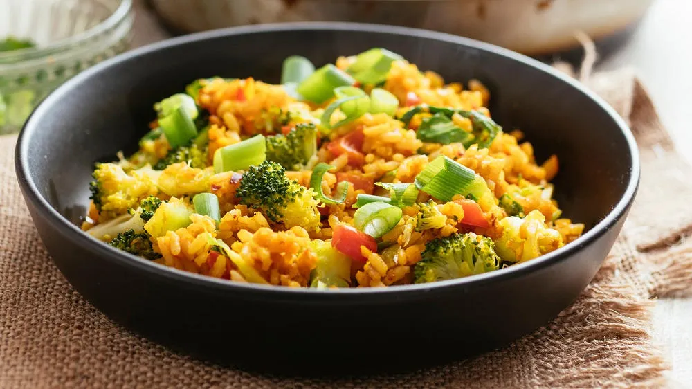 Reispfanne vegetarisch mit frischem Brokkoli und Paprika in einer Schale serviert