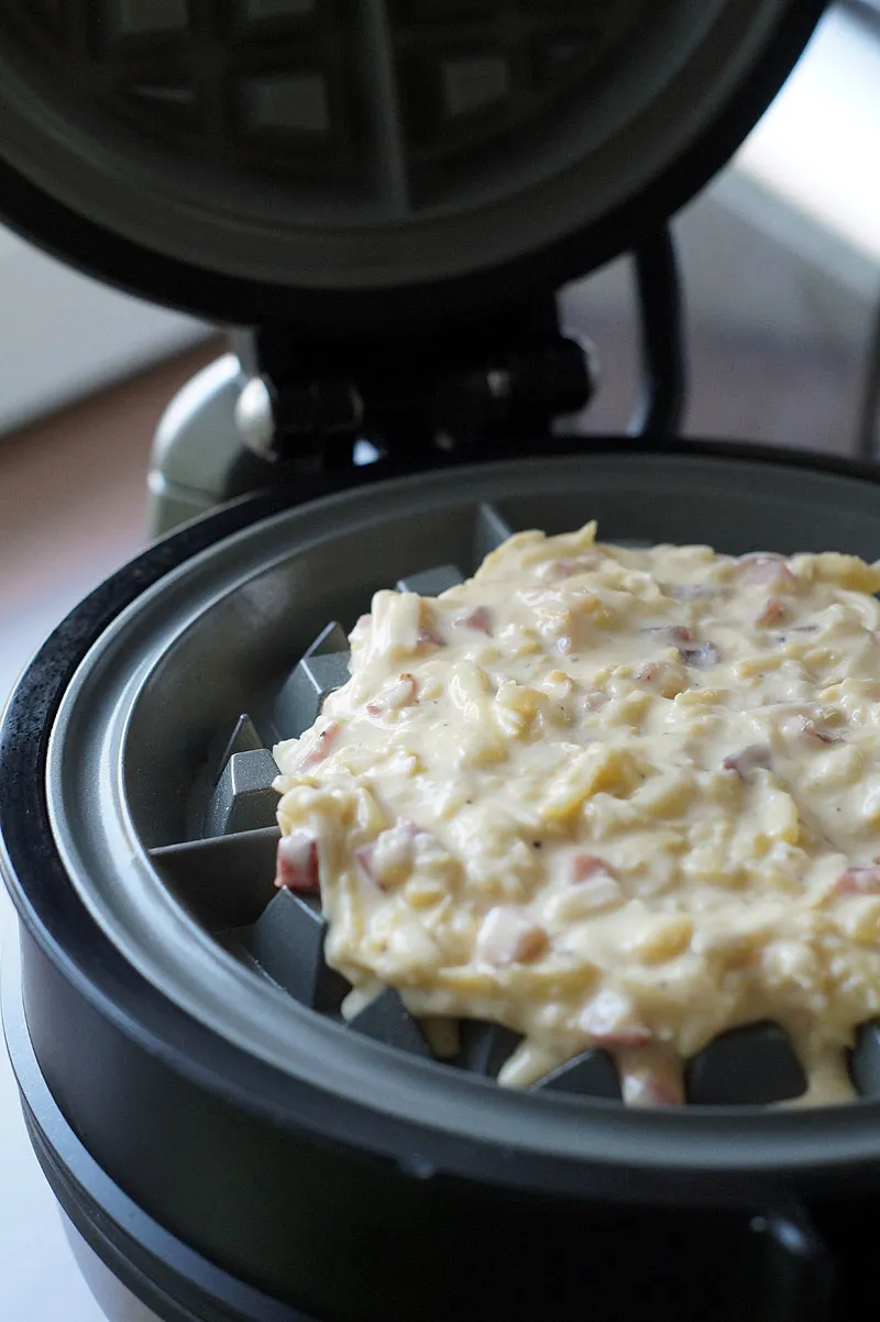 Roher Waffelteig wird in das KitchenAid Waffeleisen gefüllt