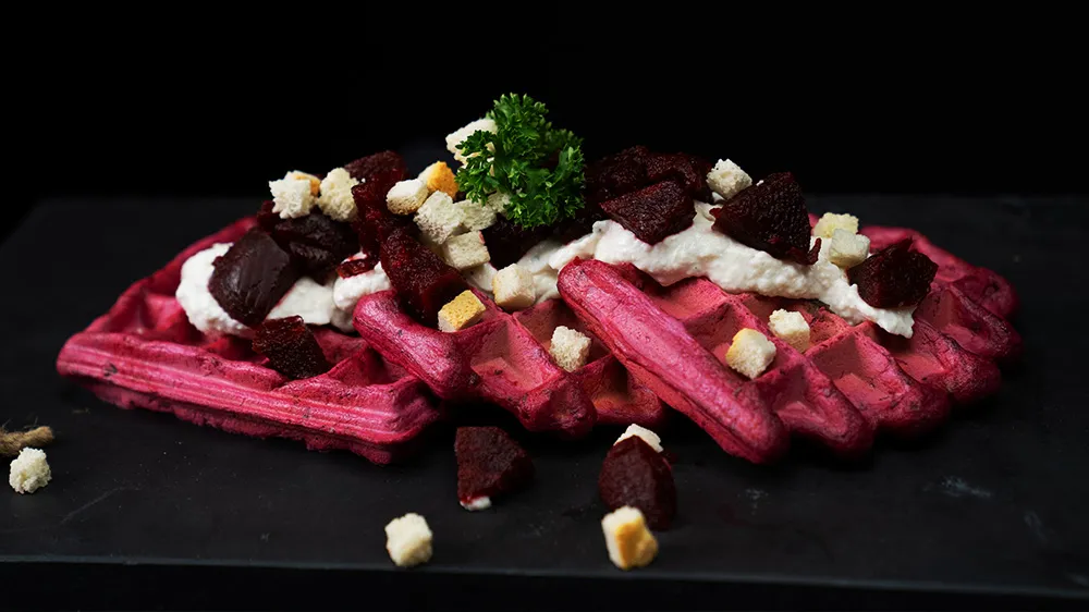 Rosa Rote-Bete-Waffeln mit einem Dip und frischen Kräutern