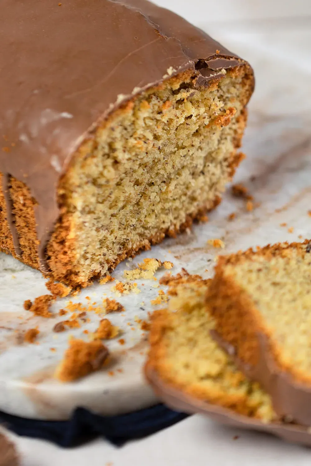 Saftiger Nusskuchen mit Schokoglasur und gehackten Haselnüssen im Teig