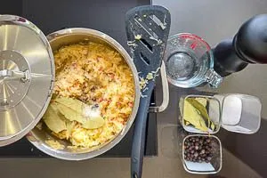 Sauerkraut wird zu den würzigen Zutaten in den Topf gegeben