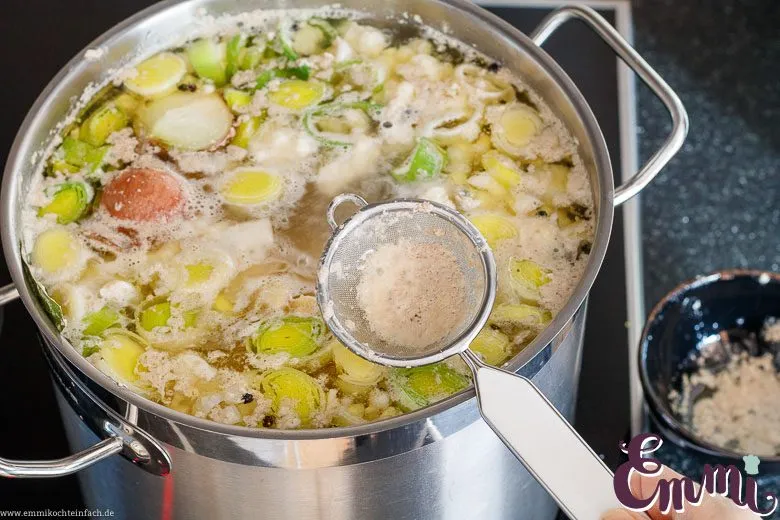 Schaum wird von der Suppe abgeschöpft