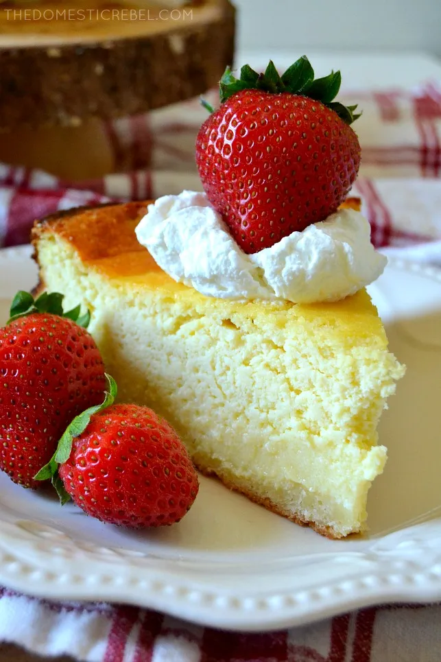 Scheibe deutscher Käsekuchen auf weißem Teller mit 3 Erdbeeren