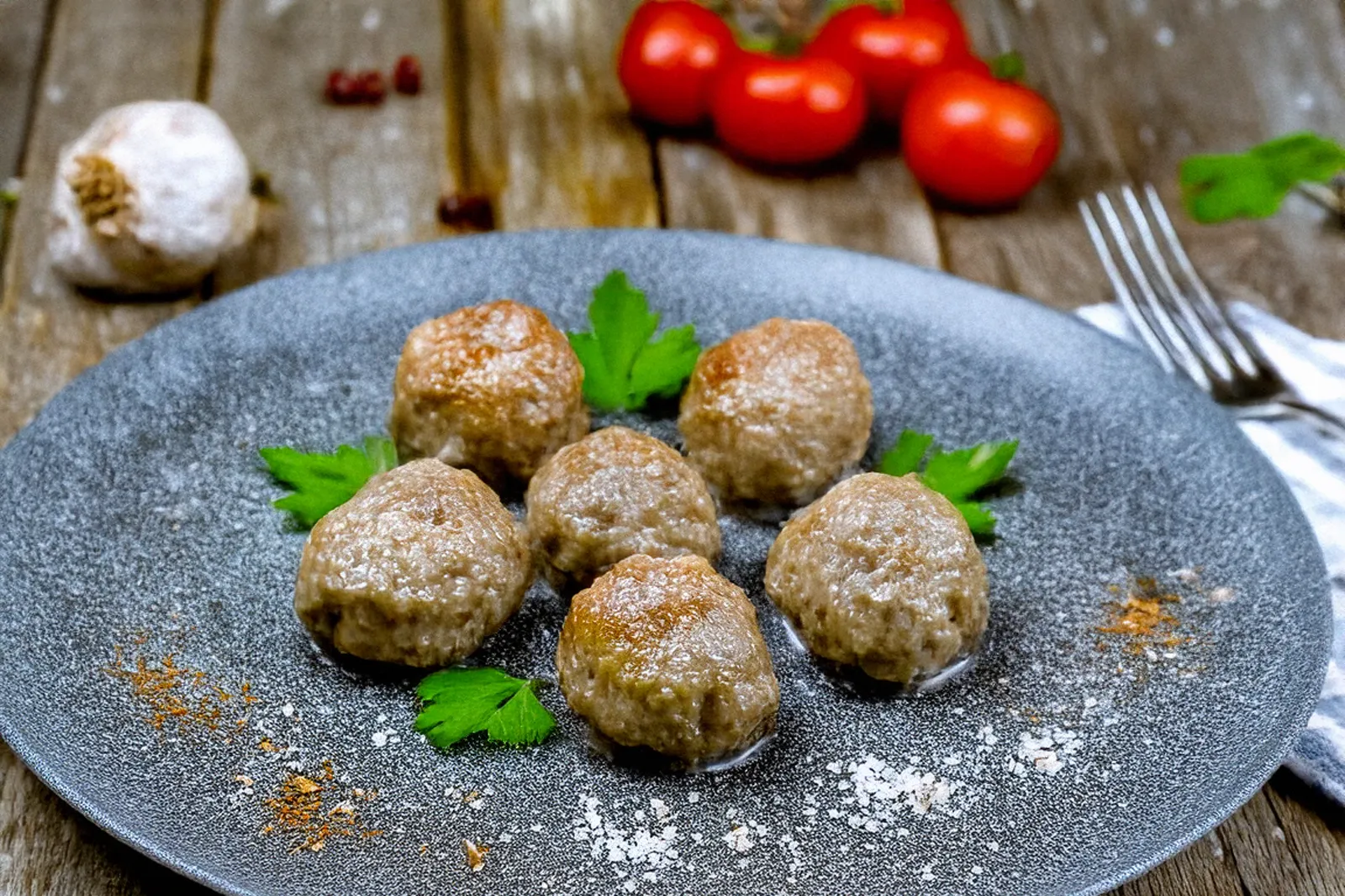 Sechs goldbraun gebratene Thunfischfrikadellen auf einem grauen Teller