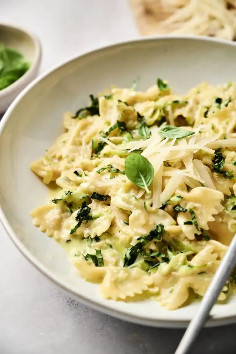 Servierfertige Zucchini Pasta in einem rustikalen Topf, dekoriert mit Kräutern