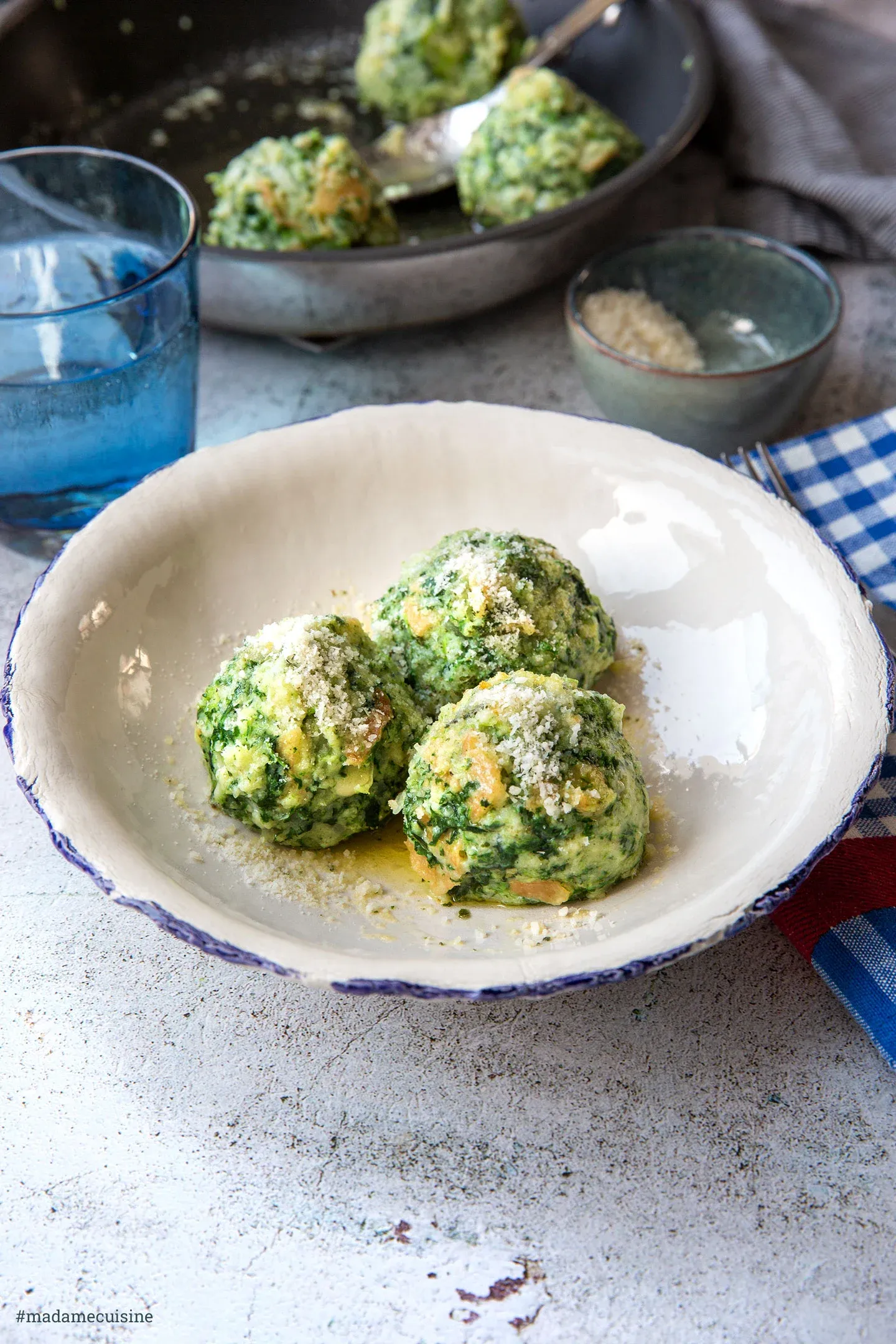 Servierte Südtiroler Spinatknödel mit Salbeibutter und Parmesan