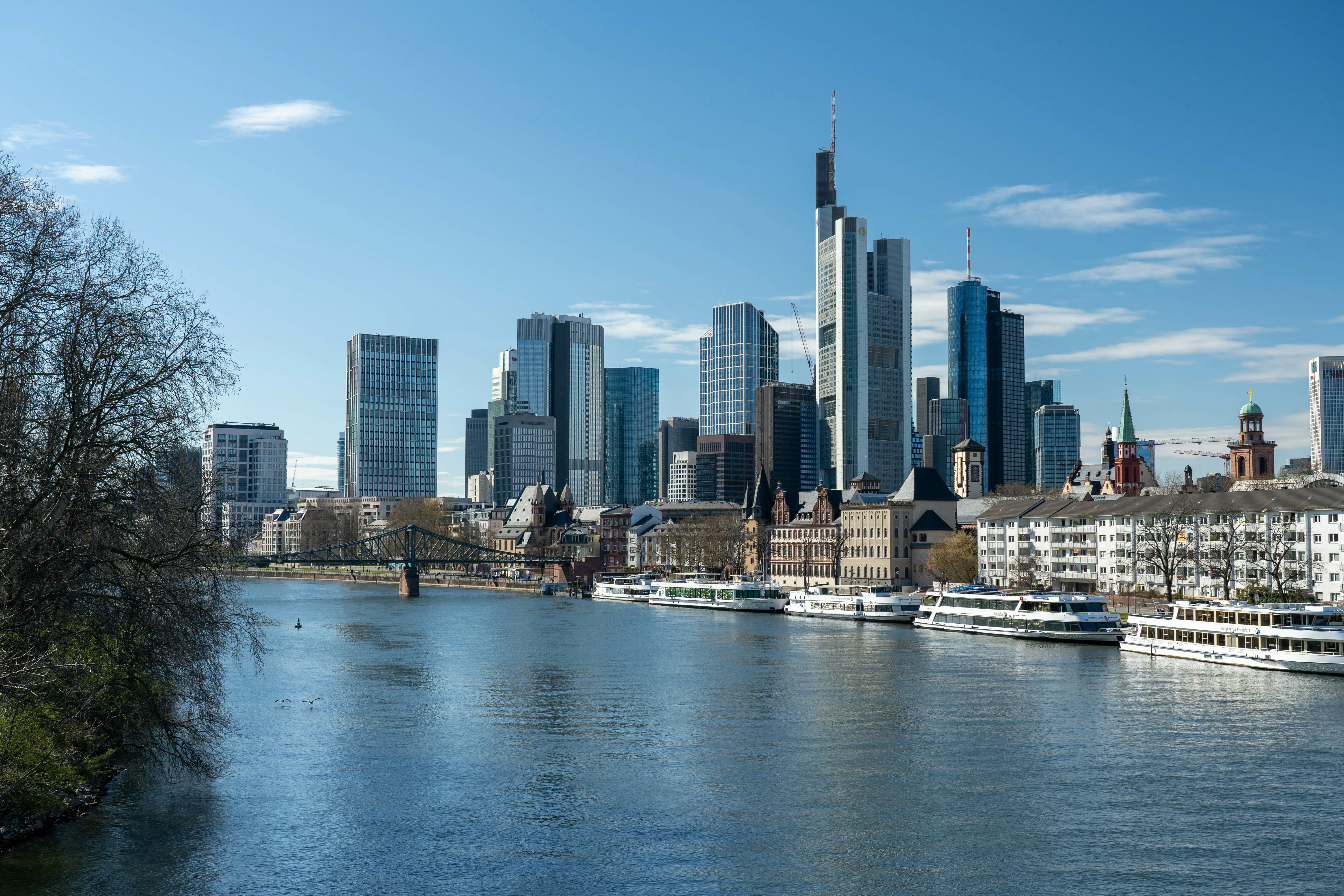 Skyline von Frankfurt am Main bei Tag, mit modernen Hochhäusern und dem Main