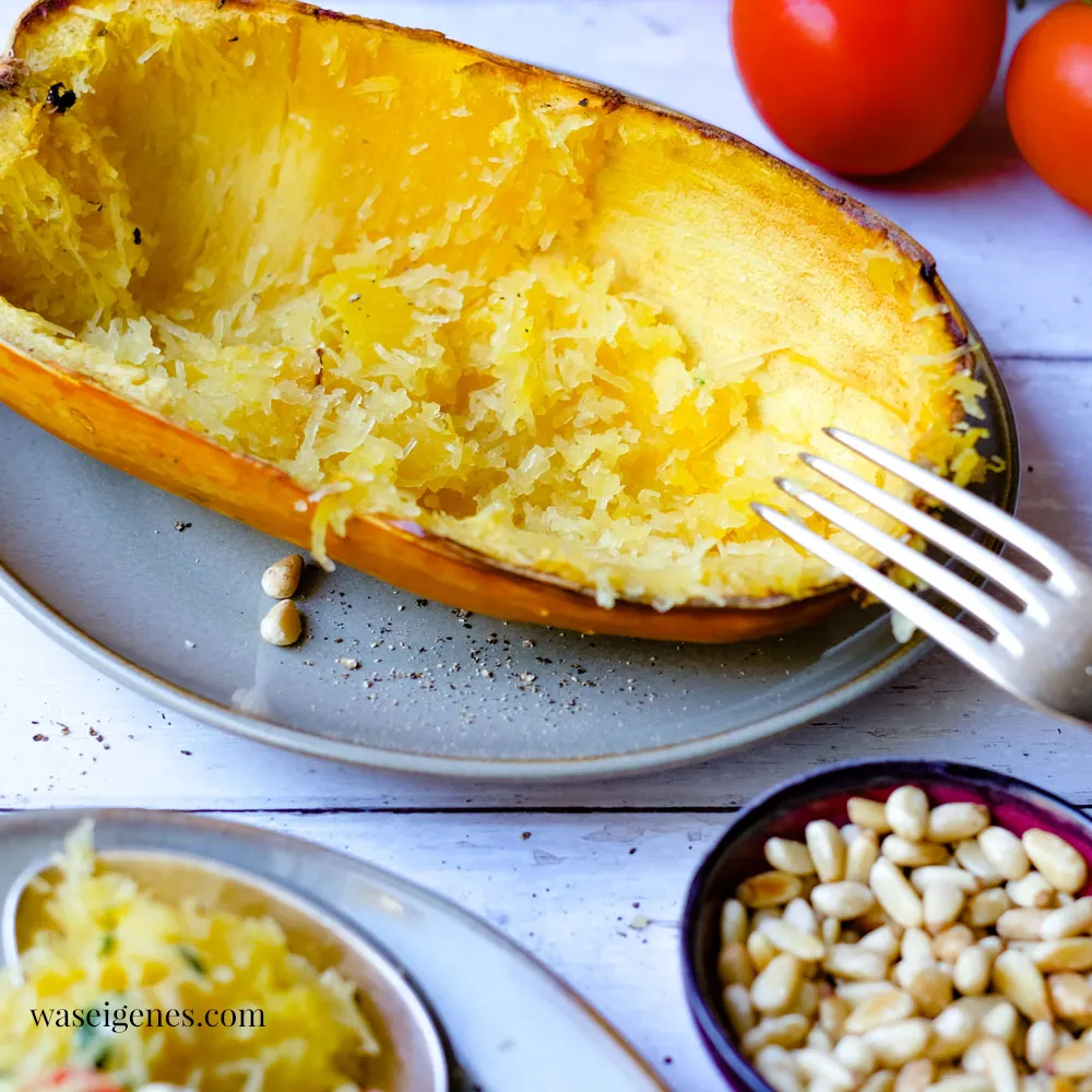 Spaghettikürbis-Hälfte, goldbraun gebacken, mit fasrigem Fruchtfleisch, bereit zum Herauskratzen