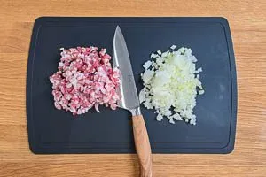 Speck und Zwiebeln werden gewürfelt