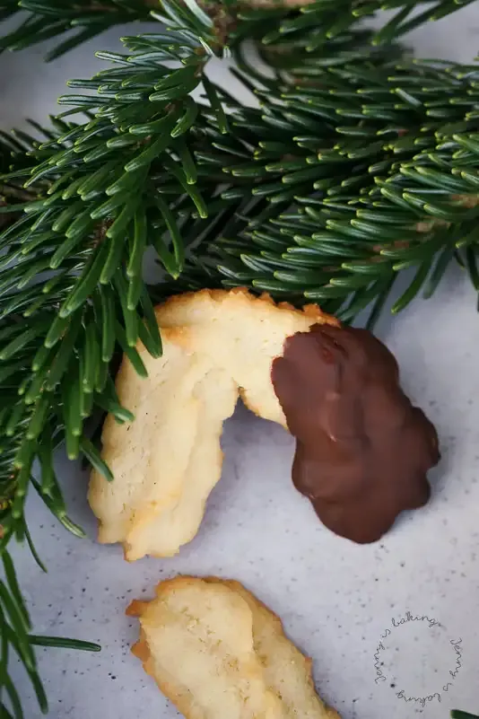Spritzgebäck-Halbmonde vor dem Backen auf Backpapier