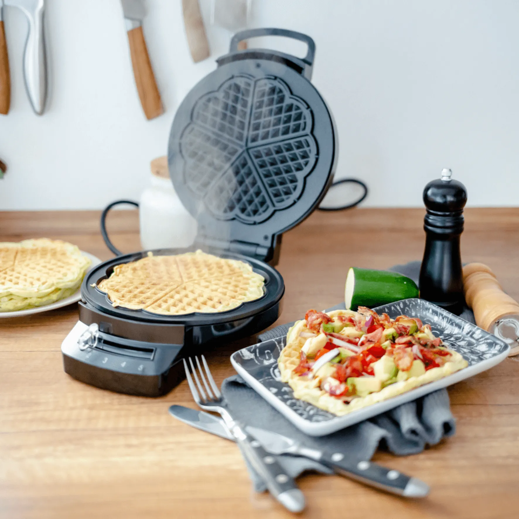 Steba Waffeleisen mit dampfendem Teig und fertigen Waffeln auf einem Teller
