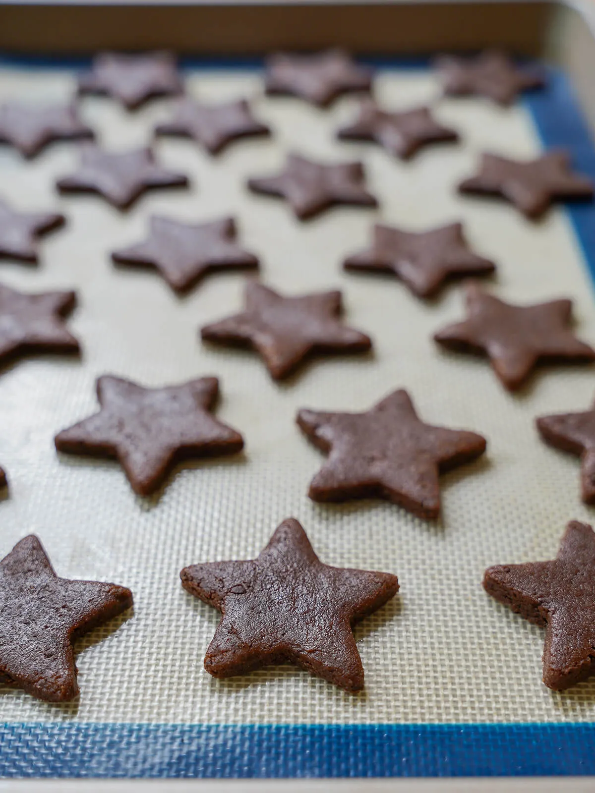 Sternförmige Kekse auf dem Backblech vor dem Backen.
