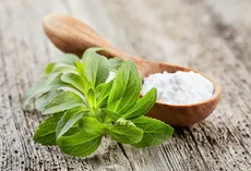 Steviablätter und weißes Stevia-Pulver als Süßstoff