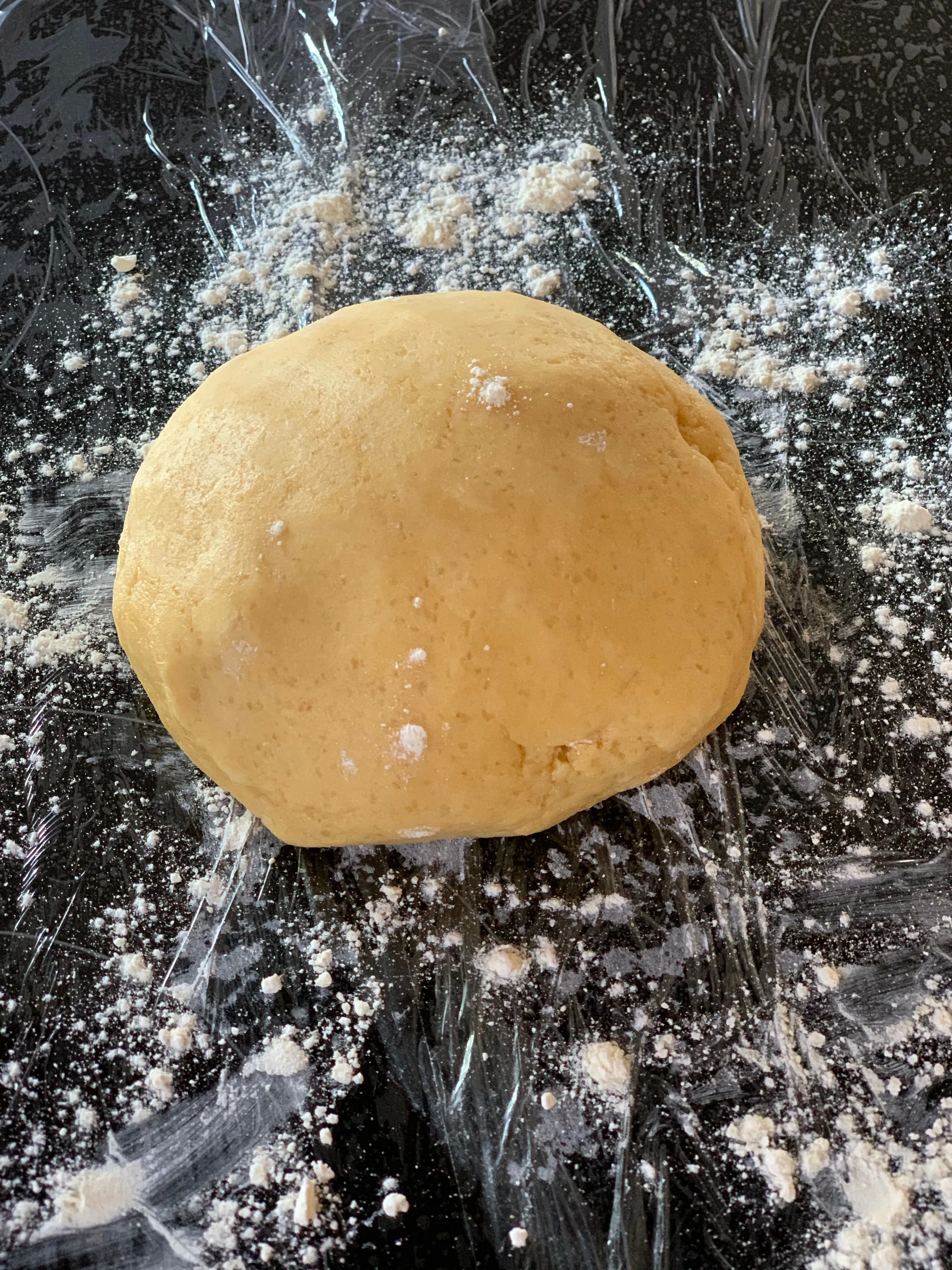 Teig kneten und auf Frischhaltefolie legen