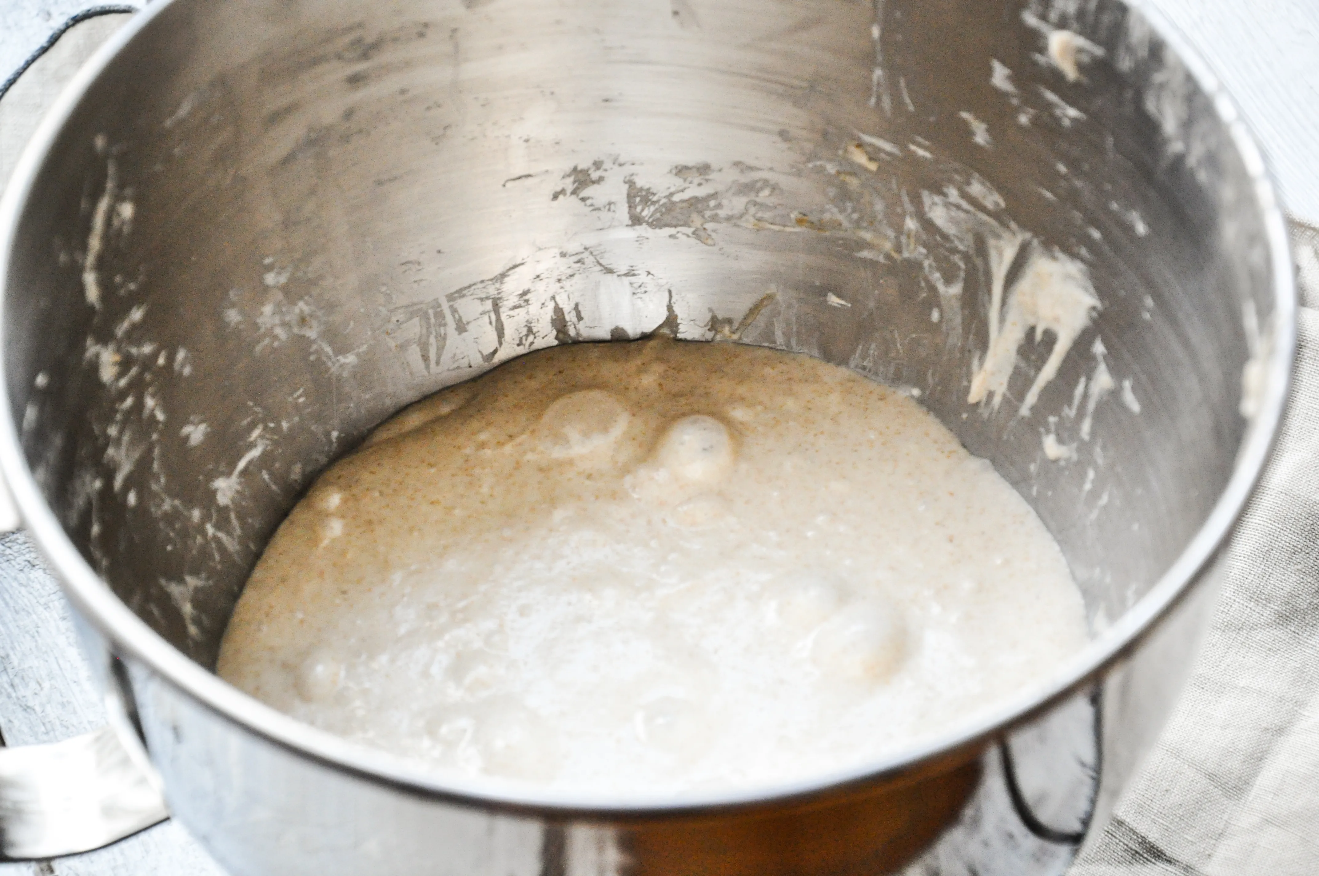 Teig wird auf einer bemehlten Fläche gedehnt und gefaltet, um seine Struktur zu stärken