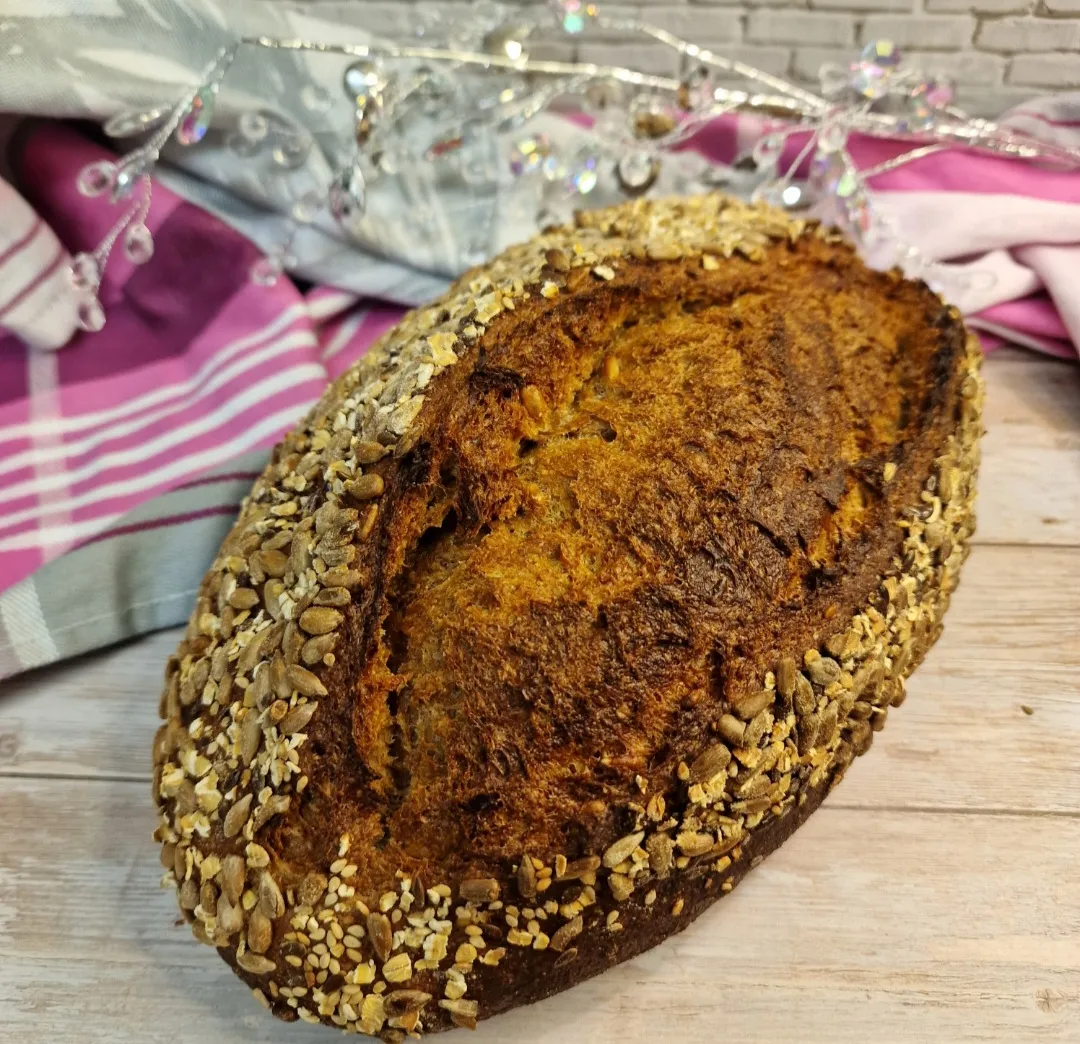 Teig wird für Brötchen geformt und in Saaten getunkt