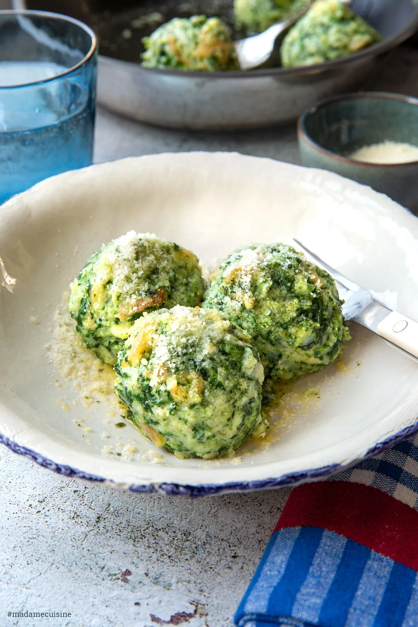 Teller mit drei Südtiroler Spinatknödeln in Salbeibutter und Parmesan
