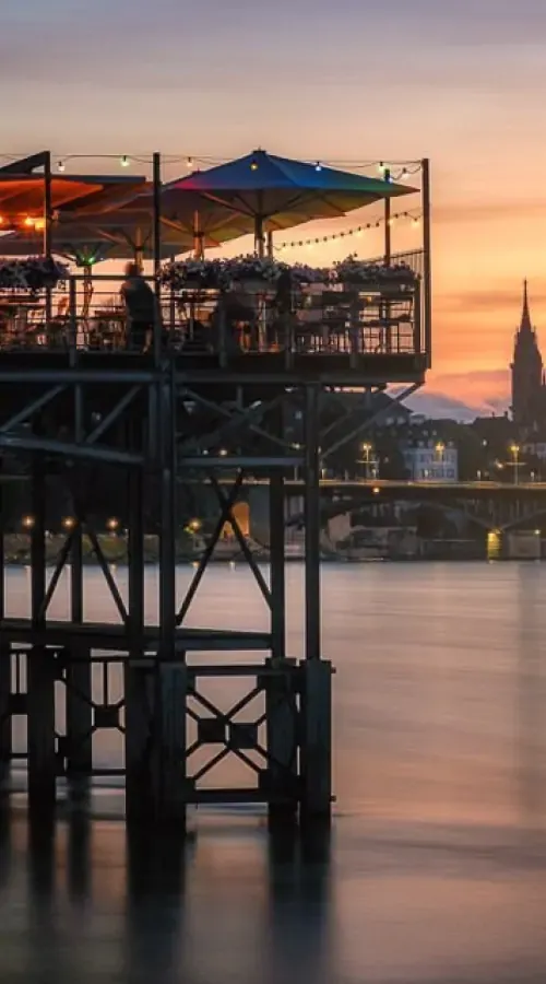 Terrasse des Le Rhin Bleu in Basel mit Blick auf den Rhein und schwimmende Boote