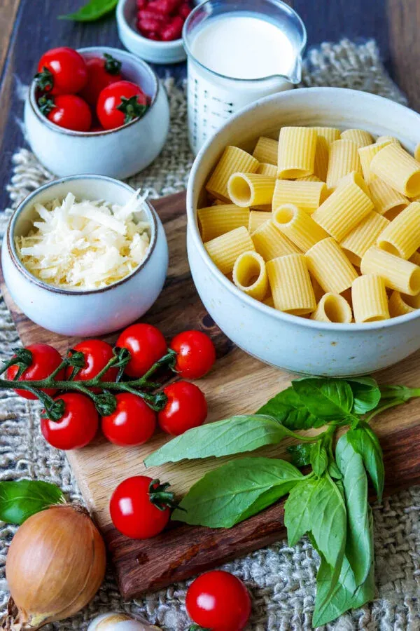 Übersicht der frischen Zutaten für One Pot Pasta auf einem Holzbrett.