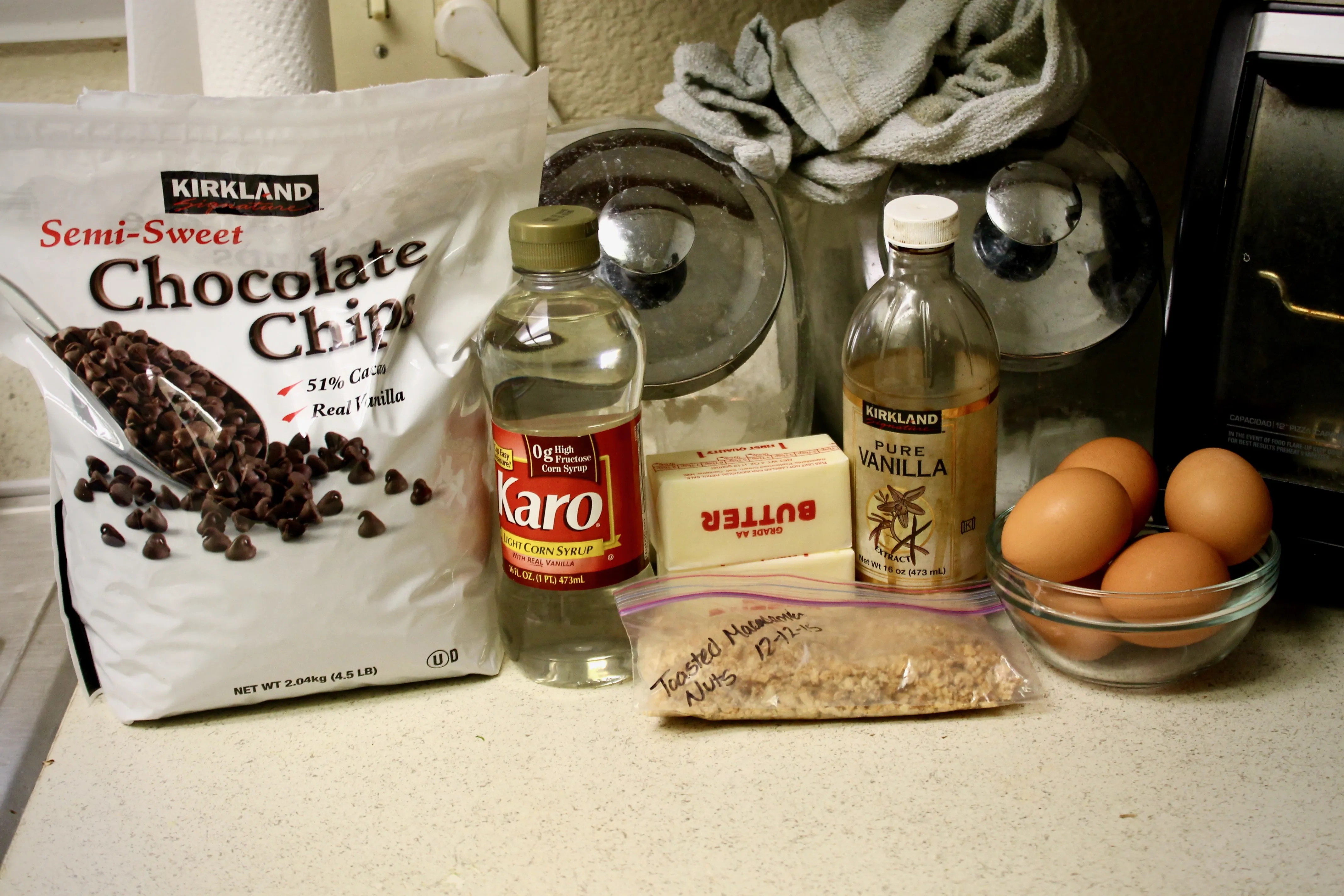Verschiedene Backzutaten für die Brownie-Torte, darunter Macadamianüsse und Schokoladenchips