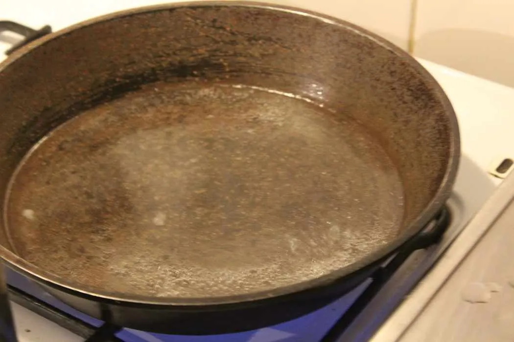 Zucker löst sich im Wasser in der Pfanne auf und beginnt zu karamellisieren