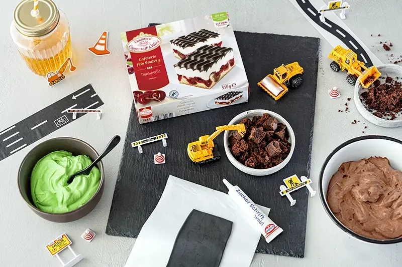 Zutaten für die Bagger-Torte auf einem Holztisch
