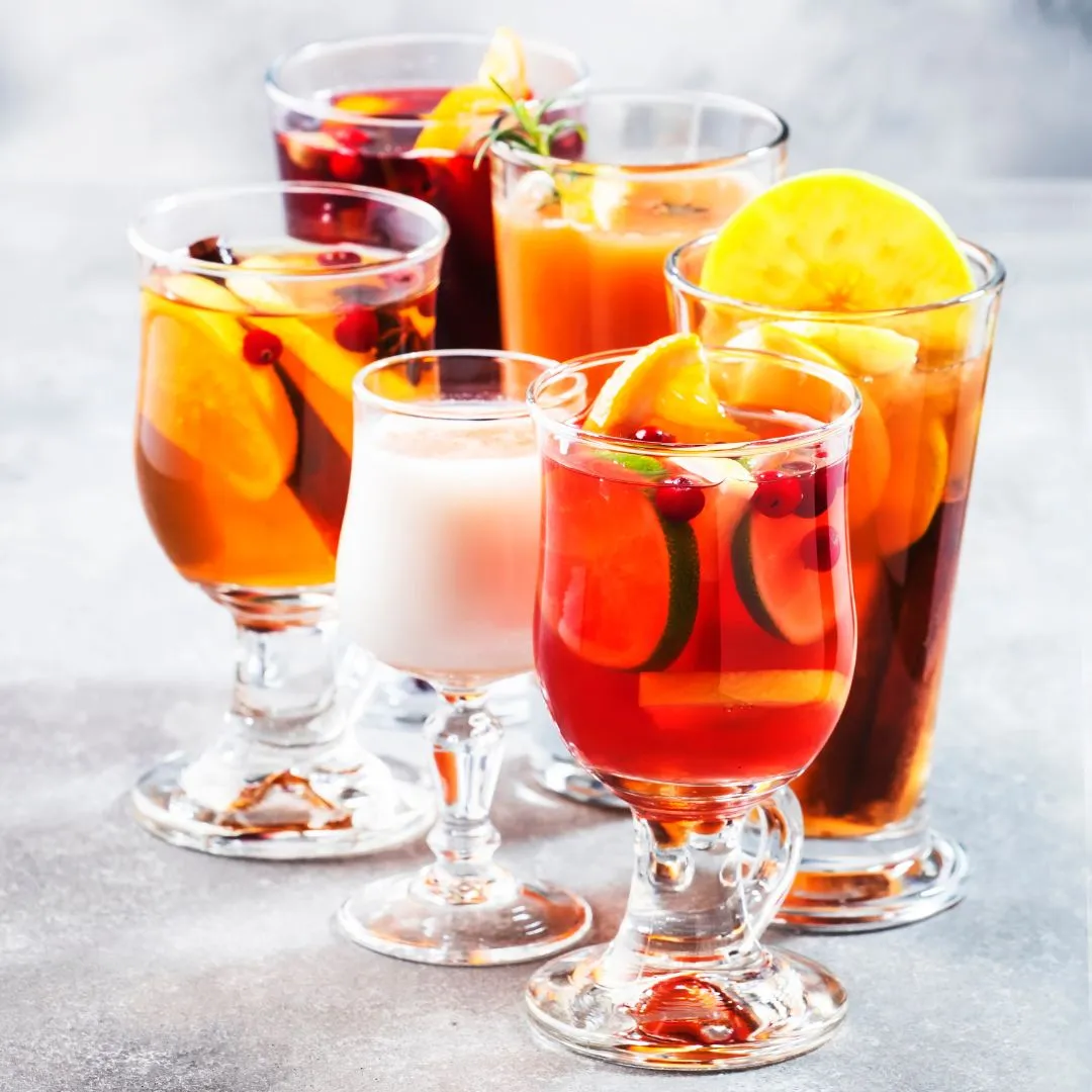 Zwei Gläser Punsch mit Orangenscheiben und Sternanis auf einem Holzbrett