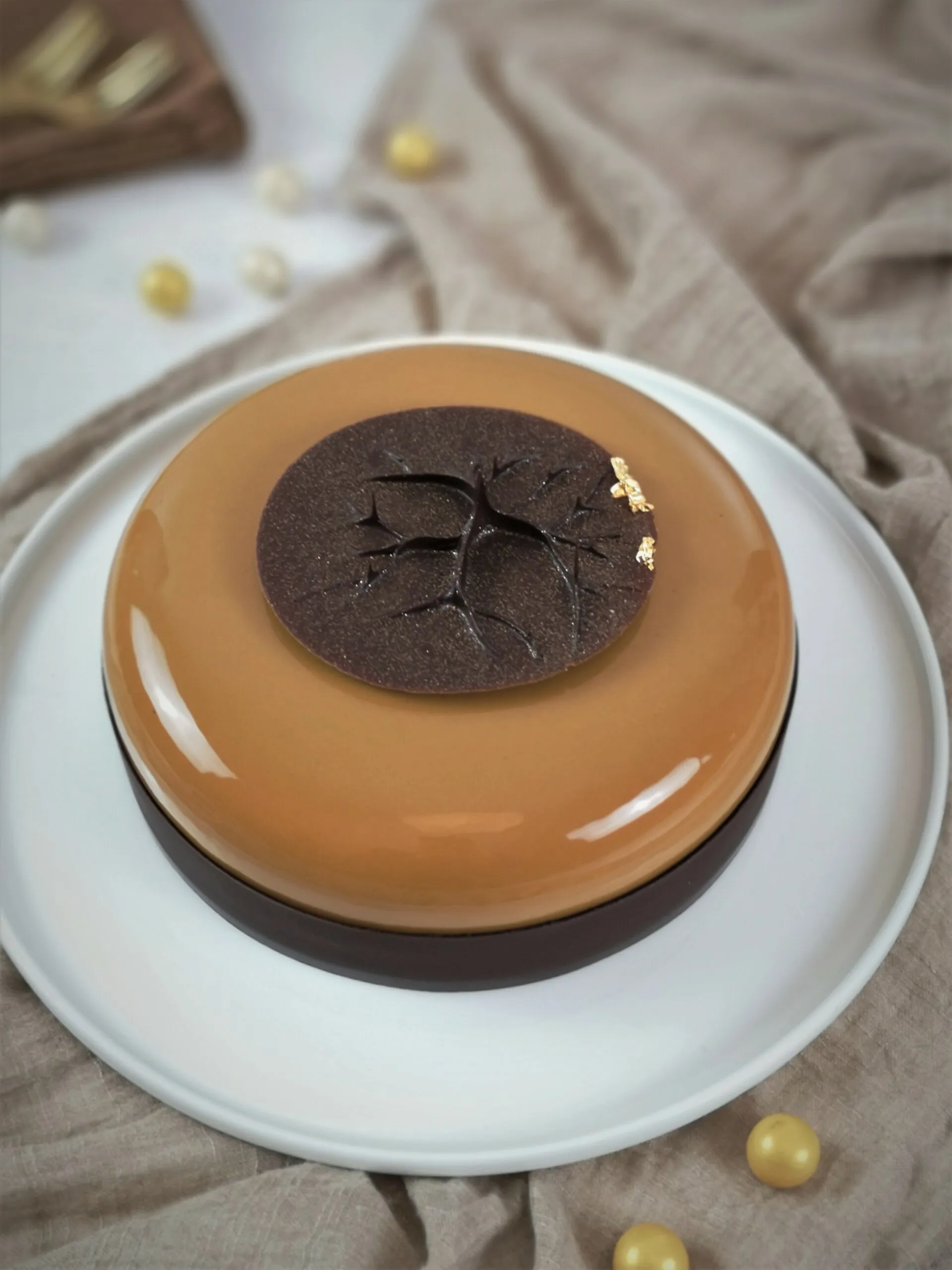 Zwei goldfarbene, filigrane Schokoladendekorationen, die an Tautropfen erinnern