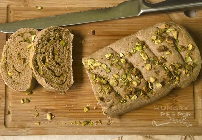 Zwei Laibe gerolltes Vollkornbrot mit Pesto und Pistazien