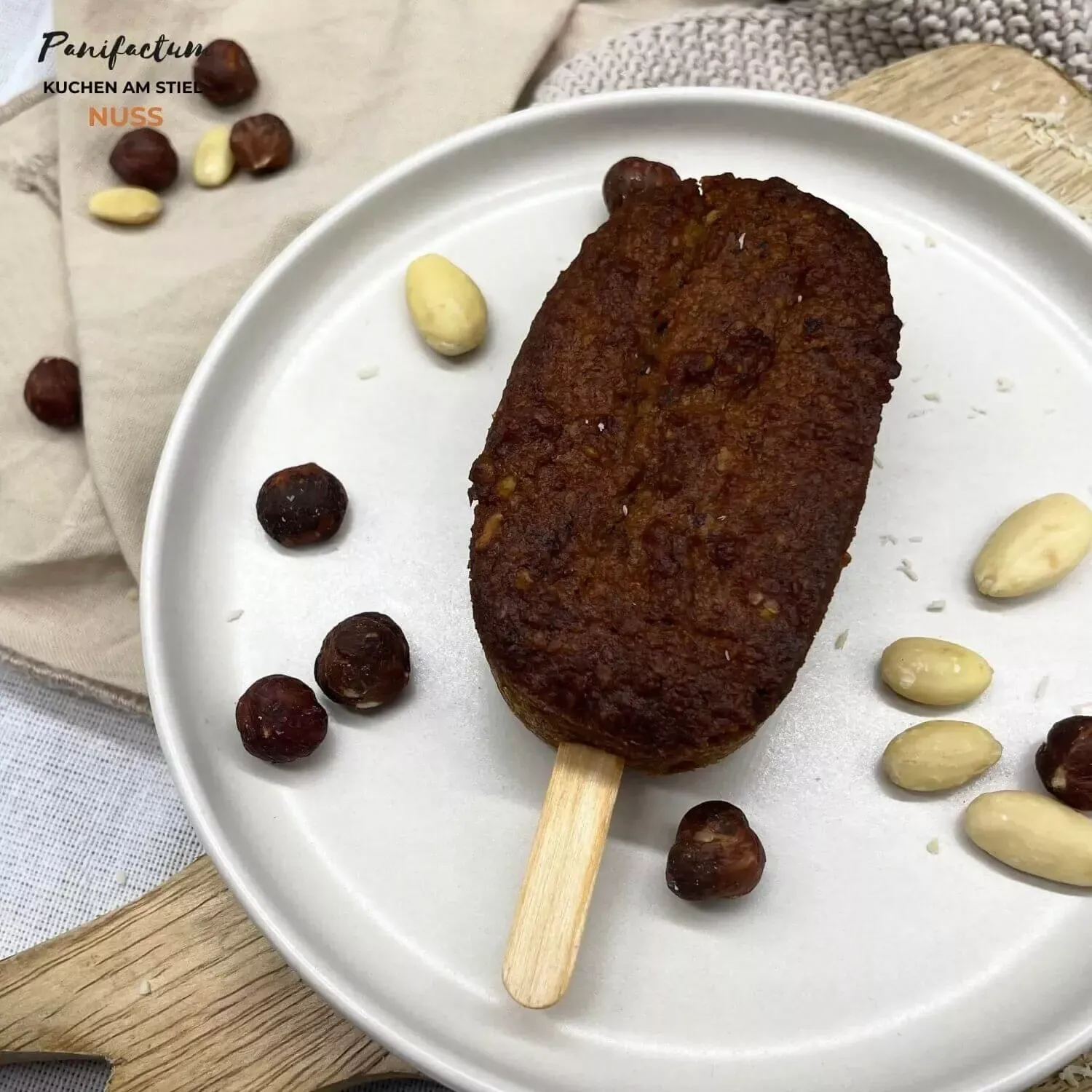 Zwei Nuss Kuchen am Stiel auf einem Teller mit Nüssen
